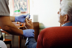 Medic attaching heart rate monitor to man's finger